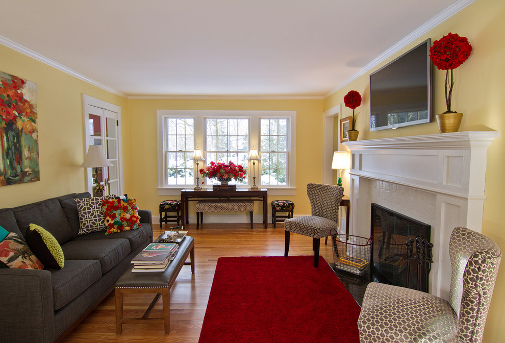 Photo of a small traditional formal open plan living room in Detroit with yellow walls, light hardwood flooring, a standard fireplace, a wooden fireplace surround and a wall mounted tv.