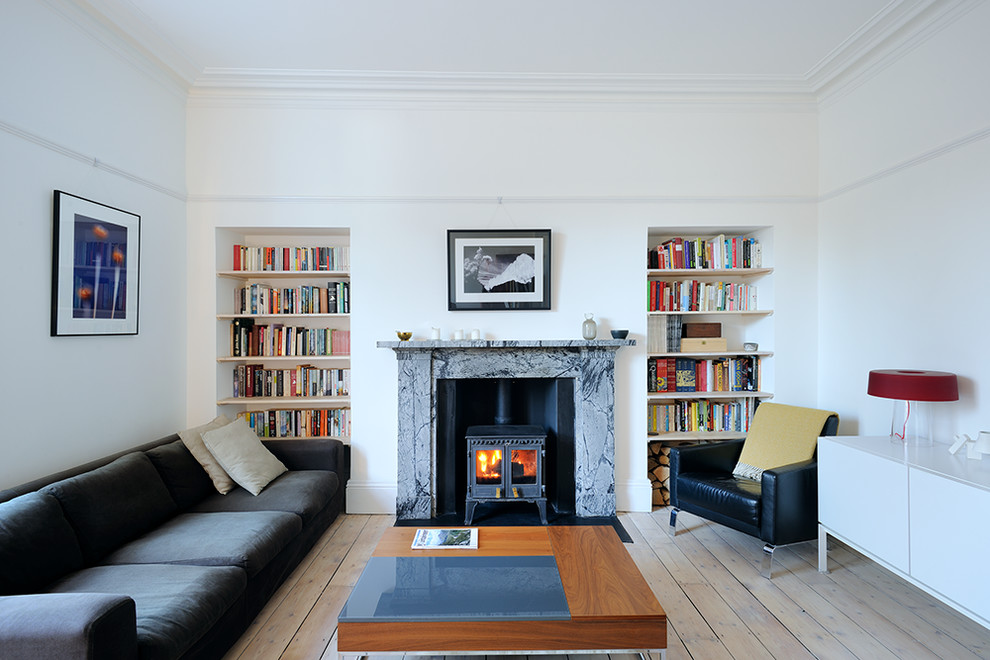 Cette photo montre un salon scandinave avec un mur blanc, un sol en bois brun, une cheminée standard et aucun téléviseur.