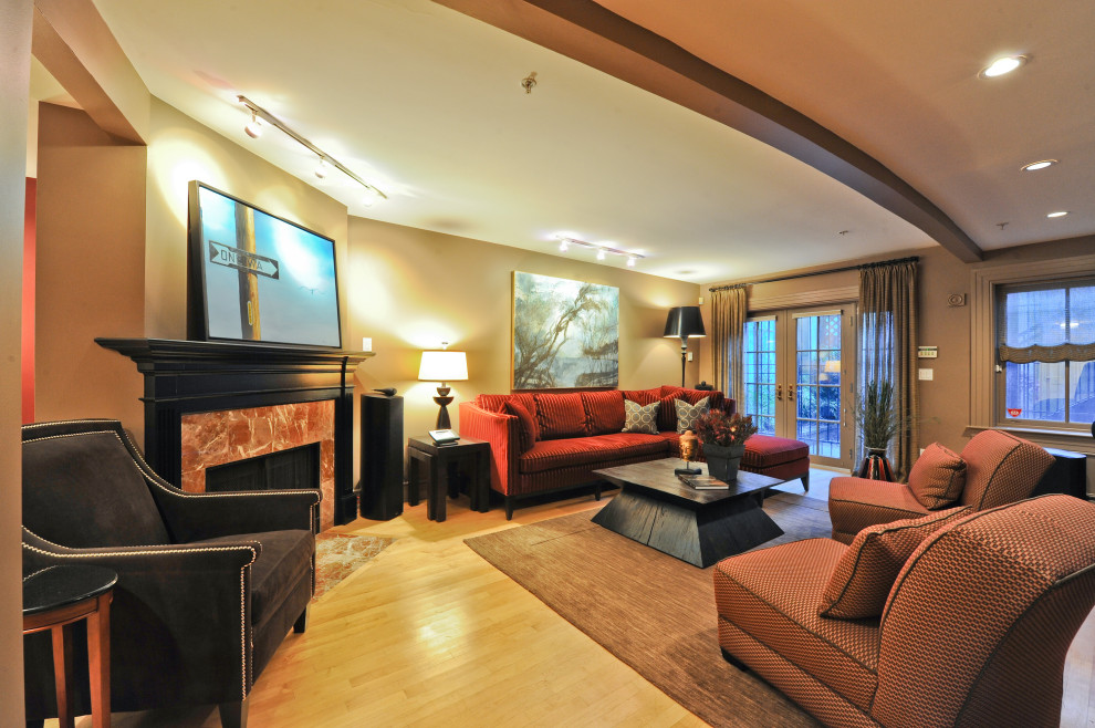This is an example of a large contemporary open plan living room in Boston with beige walls, light hardwood flooring, a corner fireplace, a stone fireplace surround and yellow floors.