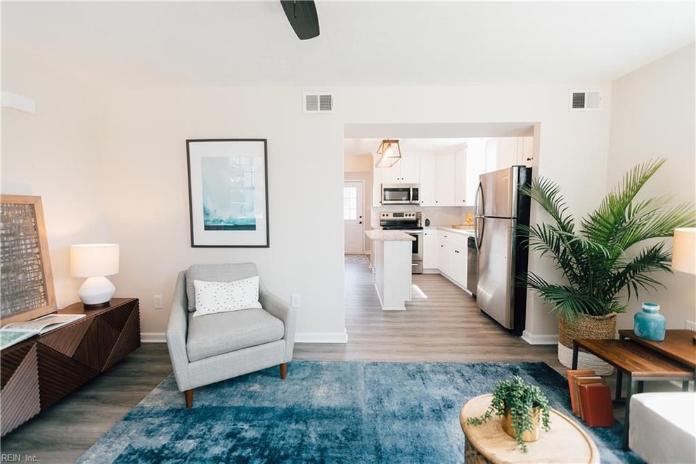 Mittelgroßes, Abgetrenntes Modernes Wohnzimmer mit beiger Wandfarbe, Vinylboden, freistehendem TV und grauem Boden in Sonstige