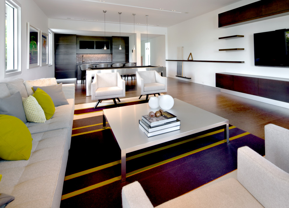 Foto di un grande soggiorno design aperto con pareti bianche, pavimento in legno massello medio, TV a parete e pavimento marrone