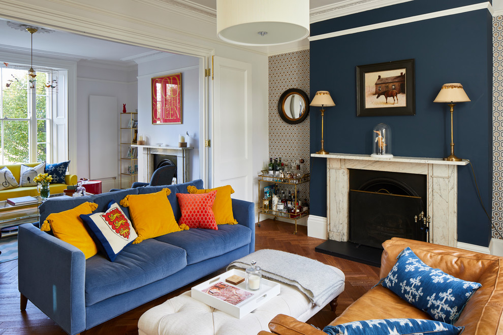 Imagen de salón cerrado clásico grande con paredes azules, suelo de madera en tonos medios, marco de chimenea de piedra y suelo marrón