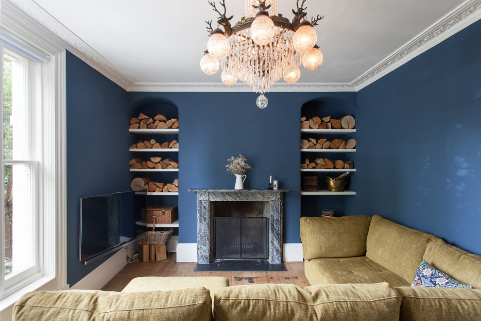 Medium sized classic living room in London with blue walls, medium hardwood flooring, a standard fireplace, a wall mounted tv and brown floors.