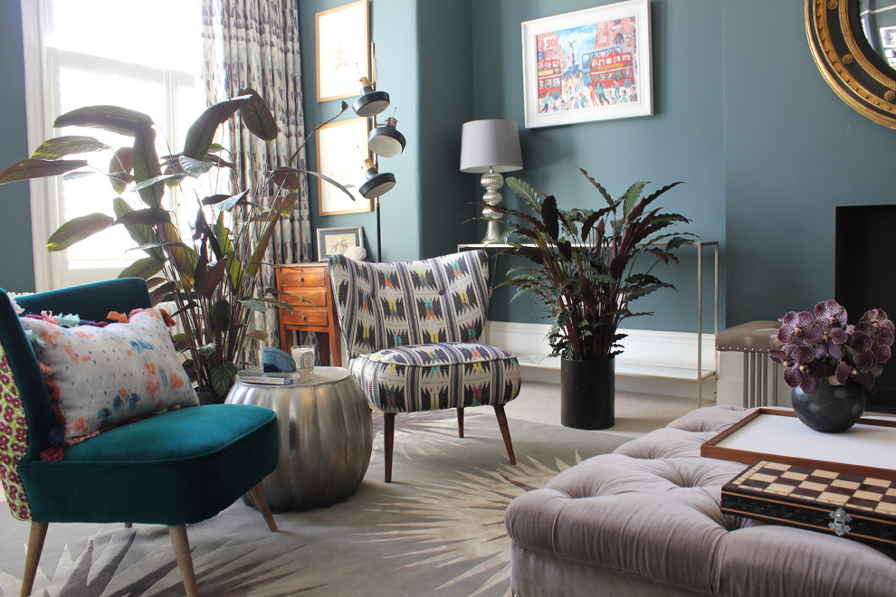 На фото: гостиная комната в викторианском стиле с синими стенами, ковровым покрытием, стандартным камином, фасадом камина из штукатурки и бежевым полом