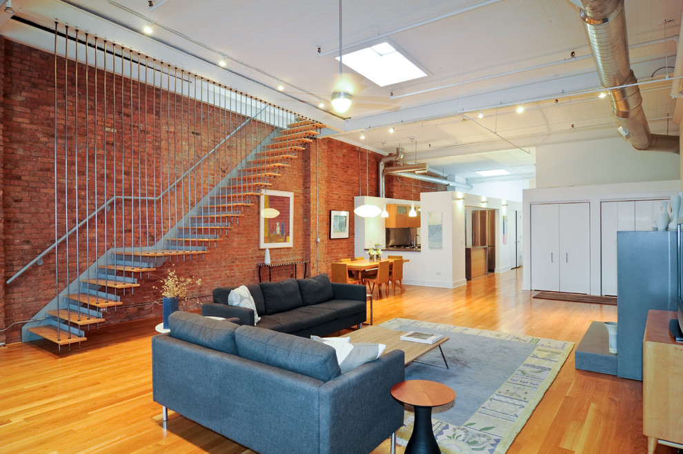 Offenes Industrial Wohnzimmer mit roter Wandfarbe und braunem Holzboden in Chicago