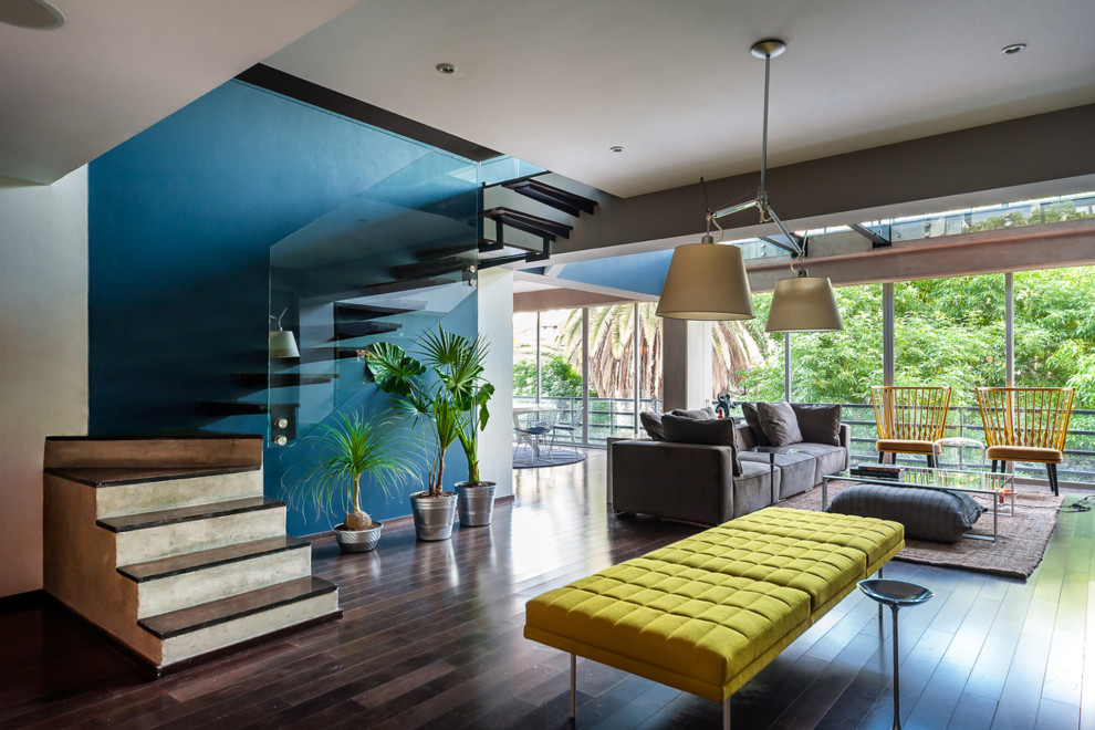 World-inspired grey and teal living room in Miami with green walls, dark hardwood flooring and brown floors.