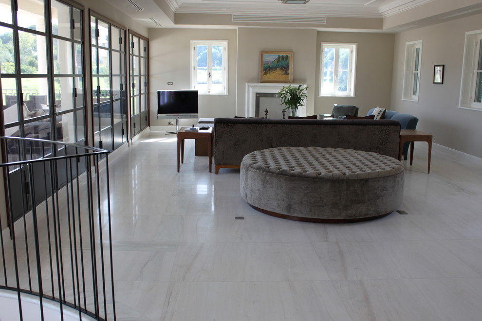 Пример оригинального дизайна: огромная открытая гостиная комната в средиземноморском стиле с домашним баром, мраморным полом, фасадом камина из камня и белым полом