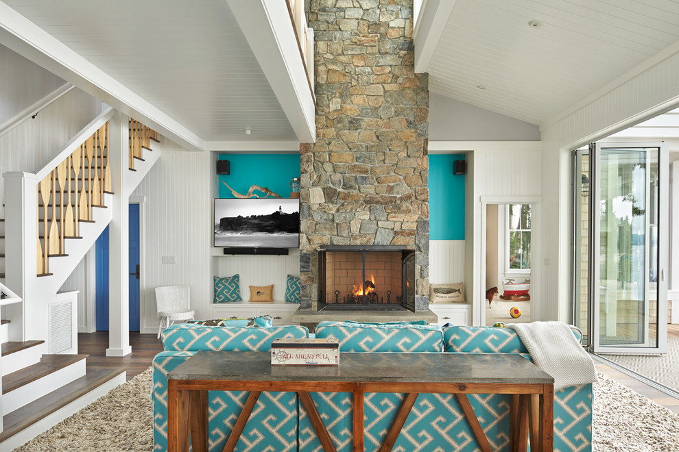 Foto di un soggiorno stile marinaro aperto con sala formale, pareti blu, camino classico e TV a parete