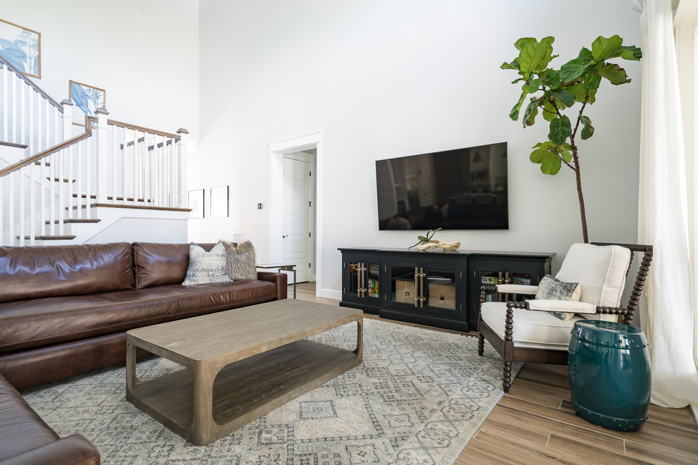 Offenes Klassisches Wohnzimmer mit grauer Wandfarbe, TV-Wand und braunem Boden in Tampa