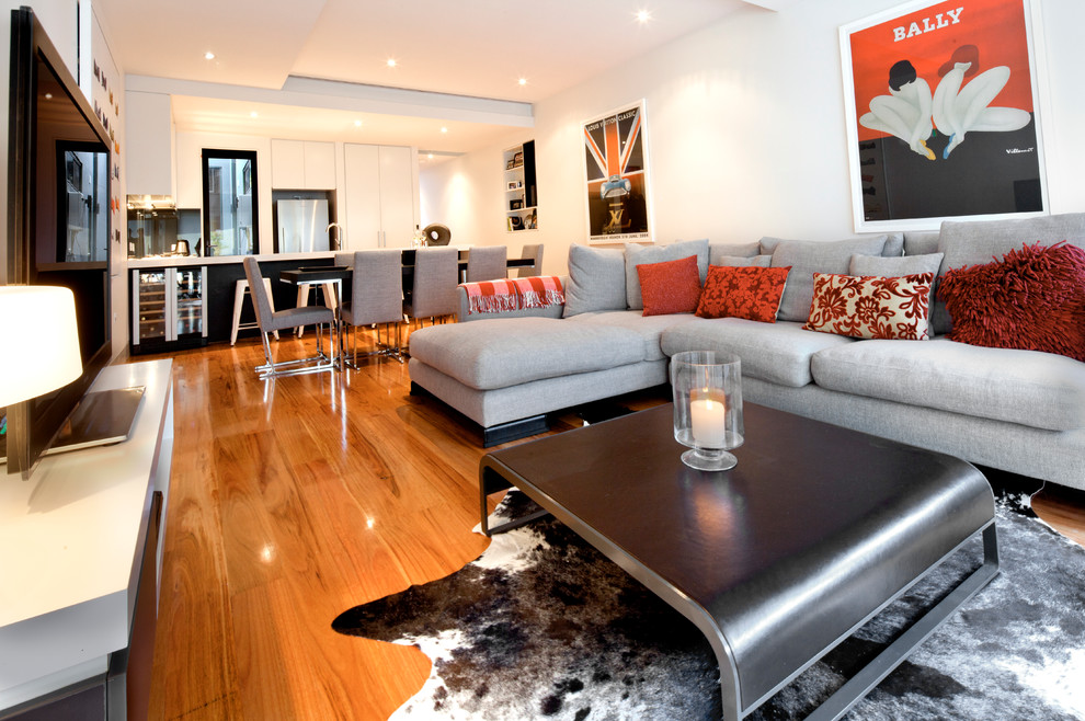 Immagine di un piccolo soggiorno moderno aperto con pareti bianche, pavimento in legno massello medio e TV autoportante
