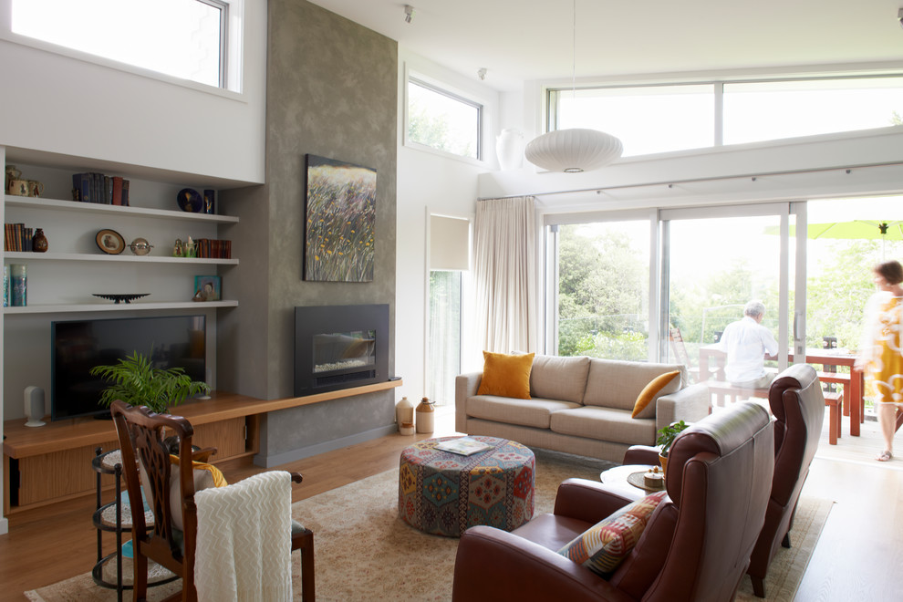 Mittelgroßes, Offenes Modernes Wohnzimmer mit weißer Wandfarbe, braunem Holzboden, Kamin, Kaminumrandung aus Metall, freistehendem TV und braunem Boden in Sonstige