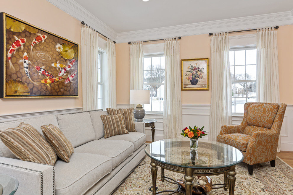 На фото: изолированная гостиная комната среднего размера в классическом стиле с оранжевыми стенами, паркетным полом среднего тона, коричневым полом и панелями на стенах