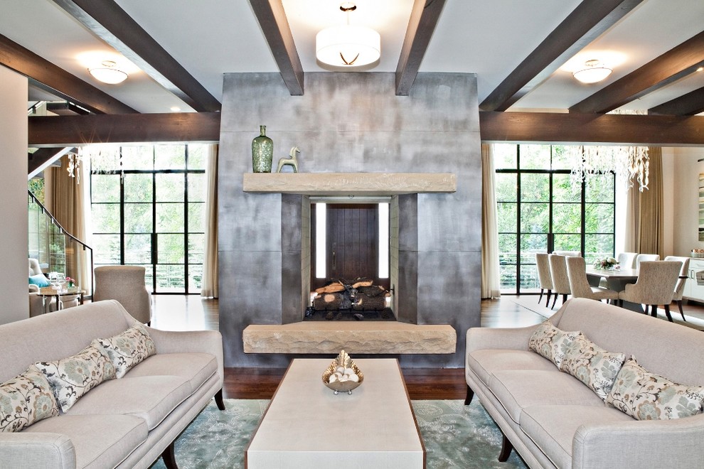 Ejemplo de salón abierto tradicional renovado de tamaño medio con paredes blancas, suelo de madera en tonos medios, chimenea de doble cara y marco de chimenea de metal