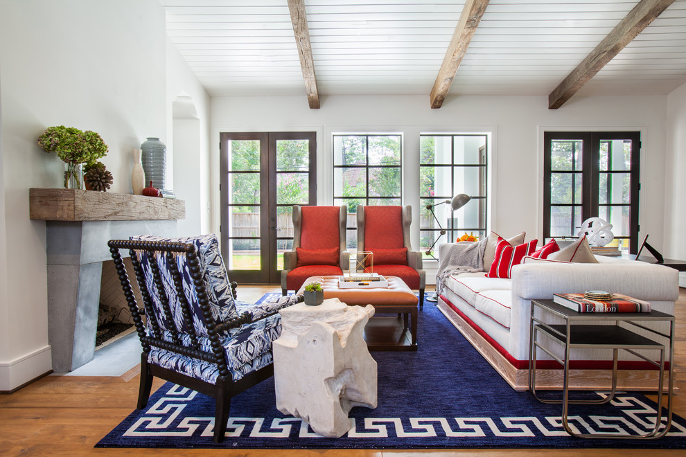 Immagine di un soggiorno tradizionale con pareti bianche, pavimento in legno massello medio e camino classico
