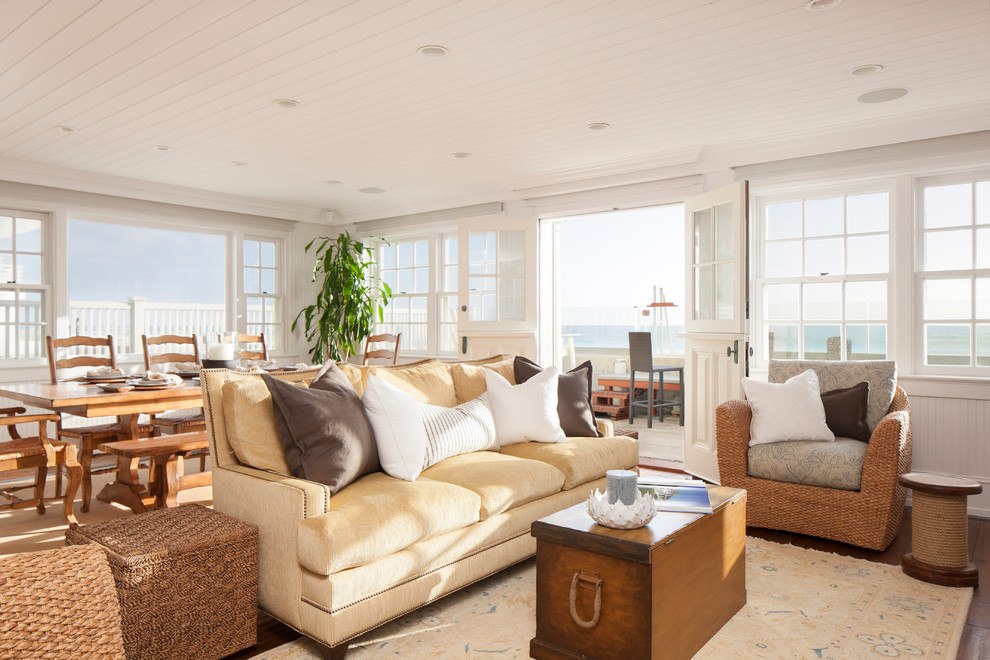 Cette photo montre un salon bord de mer de taille moyenne avec un mur blanc et un sol en bois brun.