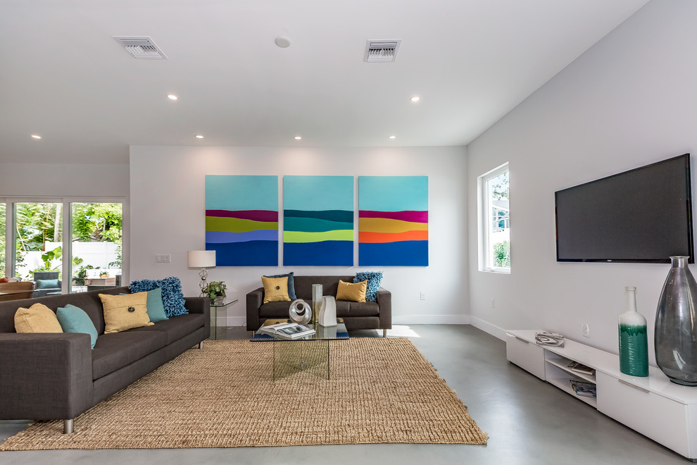タンパにあるコンテンポラリースタイルのおしゃれなLDK (白い壁、コンクリートの床、壁掛け型テレビ、グレーの床) の写真