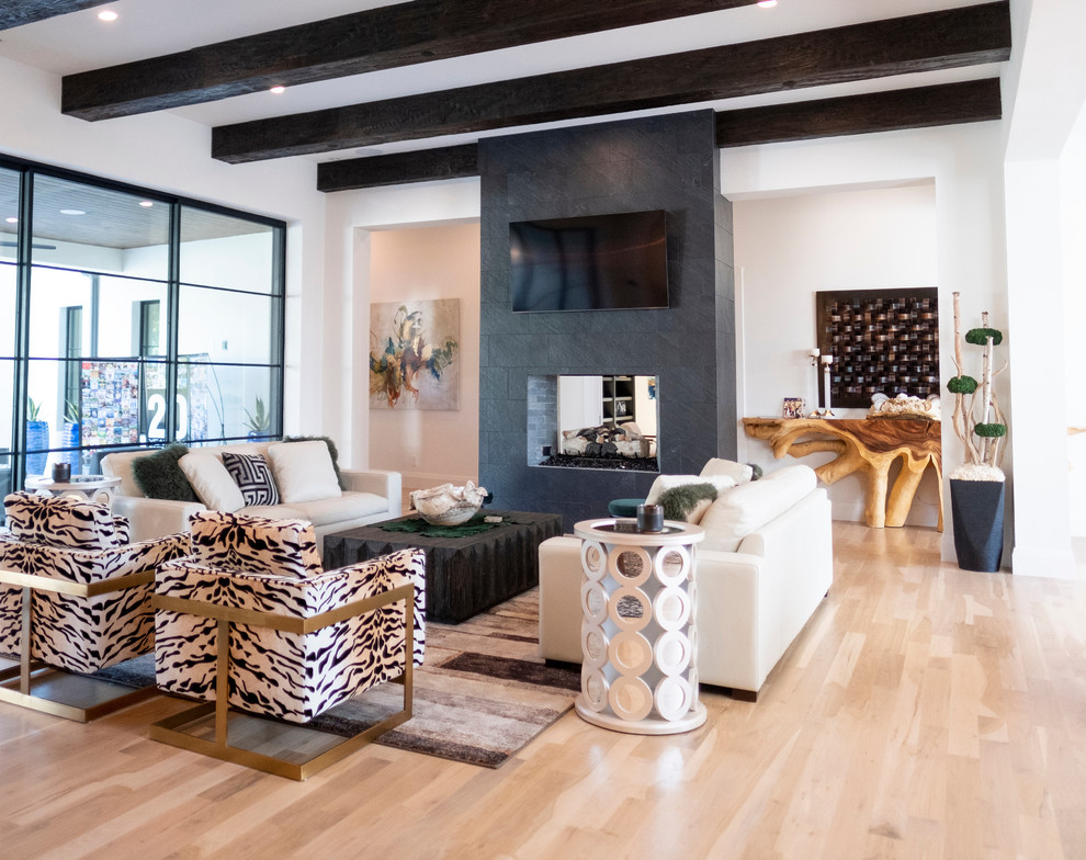 Exemple d'un grand salon tendance ouvert avec un mur blanc, parquet clair, une cheminée double-face, un manteau de cheminée en carrelage, un téléviseur fixé au mur et un sol beige.
