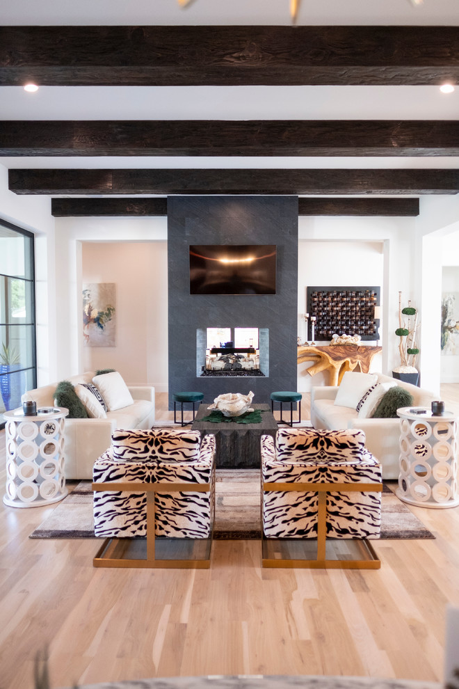 Inspiration for a large contemporary open plan living room in Dallas with white walls, light hardwood flooring, a two-sided fireplace, a tiled fireplace surround, a wall mounted tv and beige floors.