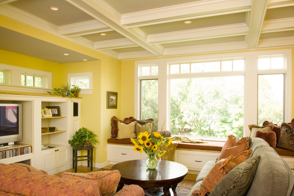 Kleines, Offenes Klassisches Wohnzimmer mit gelber Wandfarbe, hellem Holzboden, Multimediawand und Kassettendecke in Sonstige