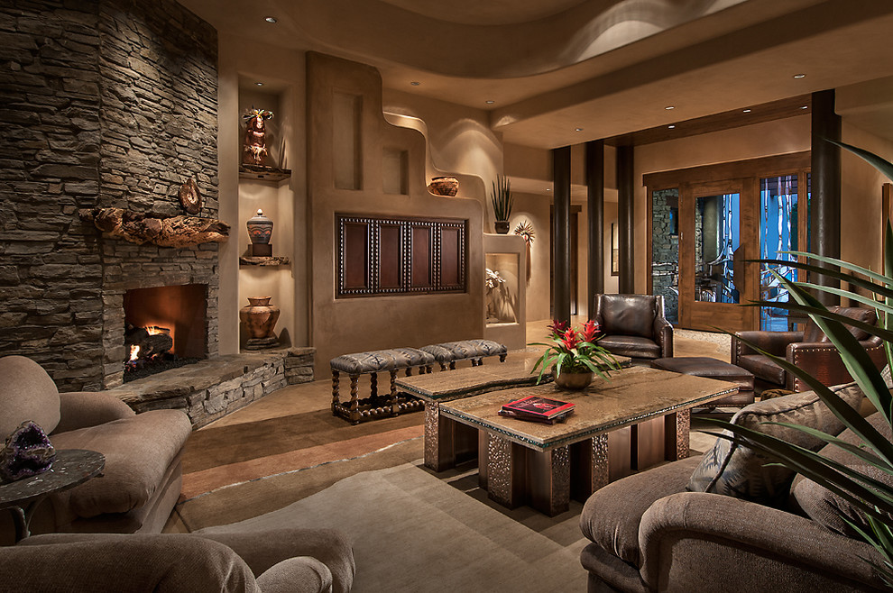 Стильный дизайн: большая открытая гостиная комната в стиле фьюжн с угловым камином, бежевыми стенами, бетонным полом, фасадом камина из камня, скрытым телевизором и коричневым диваном - последний тренд