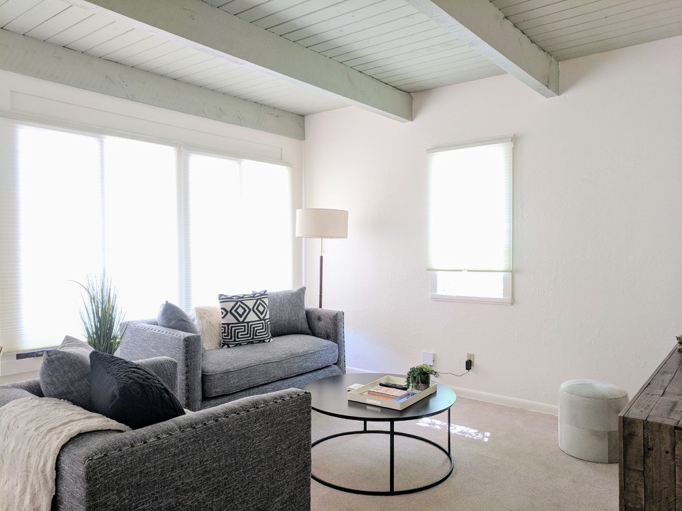 Esempio di un piccolo soggiorno american style chiuso con pareti bianche, moquette, nessun camino, TV a parete e pavimento beige