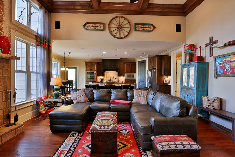 Großes, Offenes Mediterranes Wohnzimmer mit beiger Wandfarbe, braunem Holzboden, Kamin, Kaminumrandung aus Stein und freistehendem TV in Atlanta