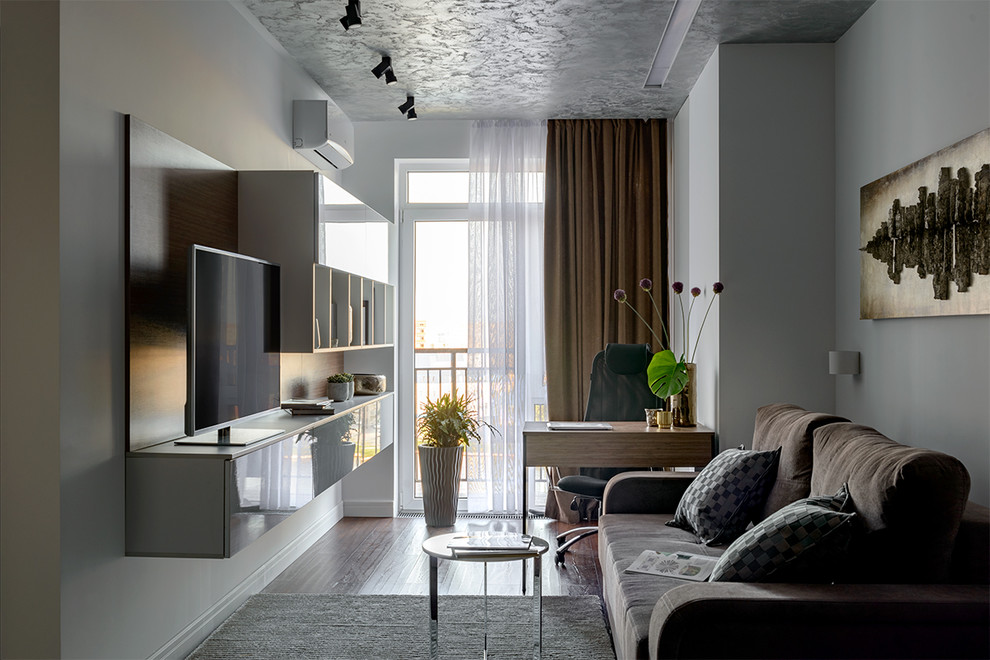 Modern inredning av ett vardagsrum, med ett finrum, vita väggar, en fristående TV och brunt golv