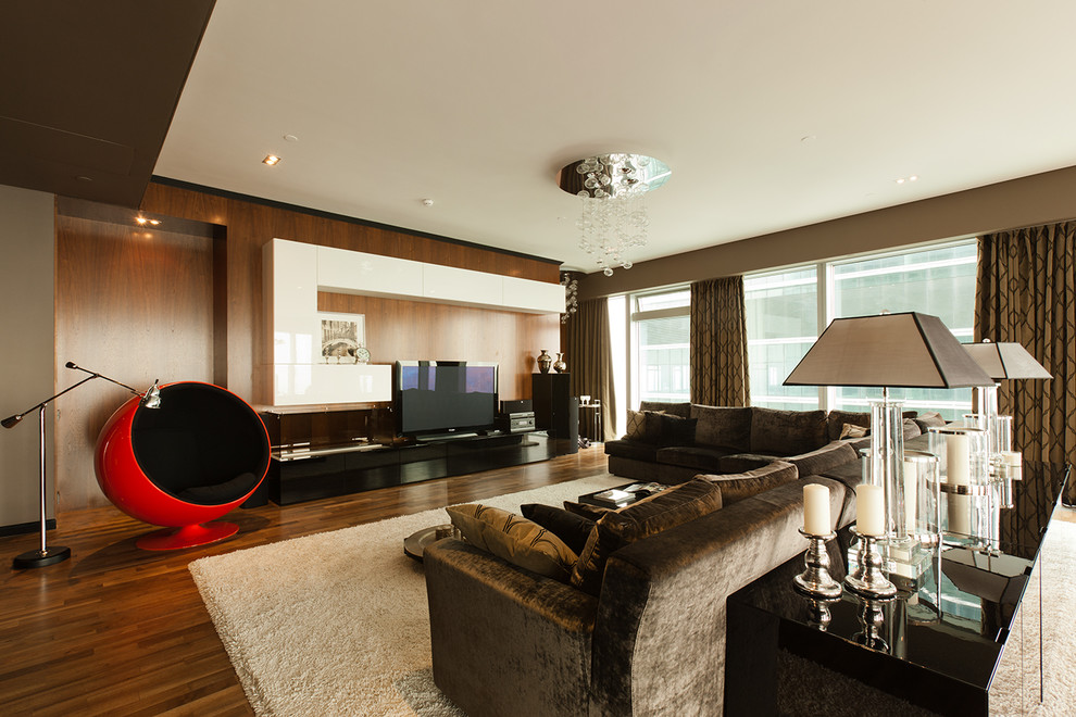 Стильный дизайн: большая гостиная комната в современном стиле с коричневыми стенами, отдельно стоящим телевизором, ковром на полу и красивыми шторами - последний тренд