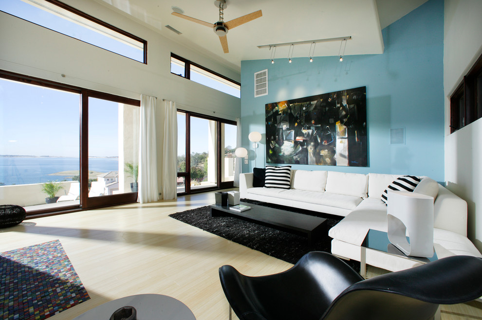 На фото: гостиная комната в современном стиле с светлым паркетным полом, синими стенами и акцентной стеной
