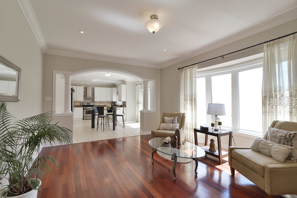 Modelo de salón moderno con paredes beige y suelo de madera en tonos medios