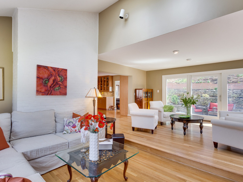 Idee per un grande soggiorno design aperto con pareti beige, parquet chiaro, pavimento beige, soffitto a volta e pareti in mattoni