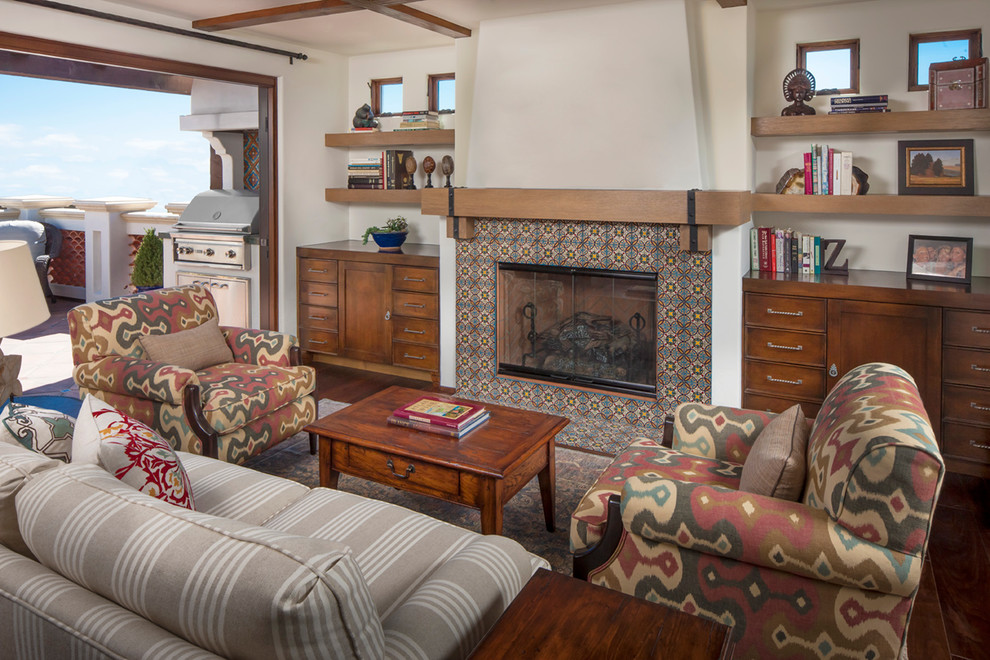 На фото: гостиная комната в средиземноморском стиле с стандартным камином и фасадом камина из плитки