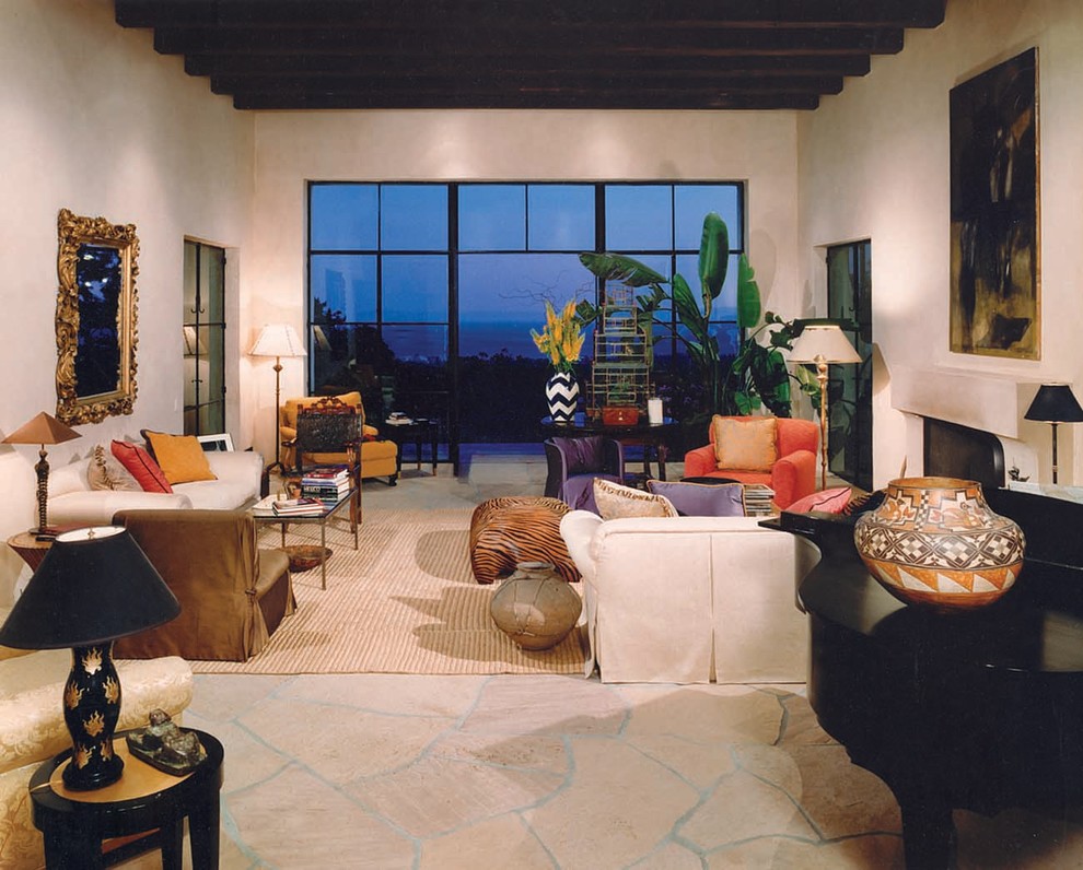 Cette photo montre un grand salon sud-ouest américain ouvert avec une salle de réception, un mur beige, un sol en ardoise, une cheminée standard, un manteau de cheminée en pierre et aucun téléviseur.