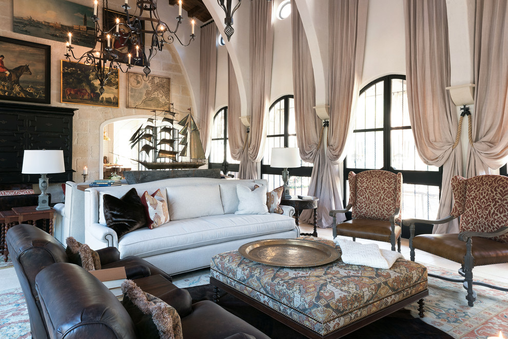 Стильный дизайн: большая парадная, изолированная гостиная комната в средиземноморском стиле с полом из известняка, стандартным камином и фасадом камина из штукатурки без телевизора - последний тренд