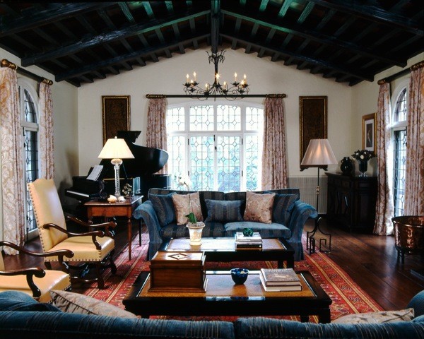 Esempio di un soggiorno classico con pavimento in legno massello medio, camino classico, cornice del camino in pietra e TV nascosta