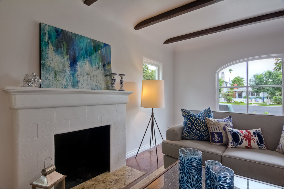 Small southwest formal and open concept medium tone wood floor living room photo in San Diego with white walls, a standard fireplace, a plaster fireplace and no tv
