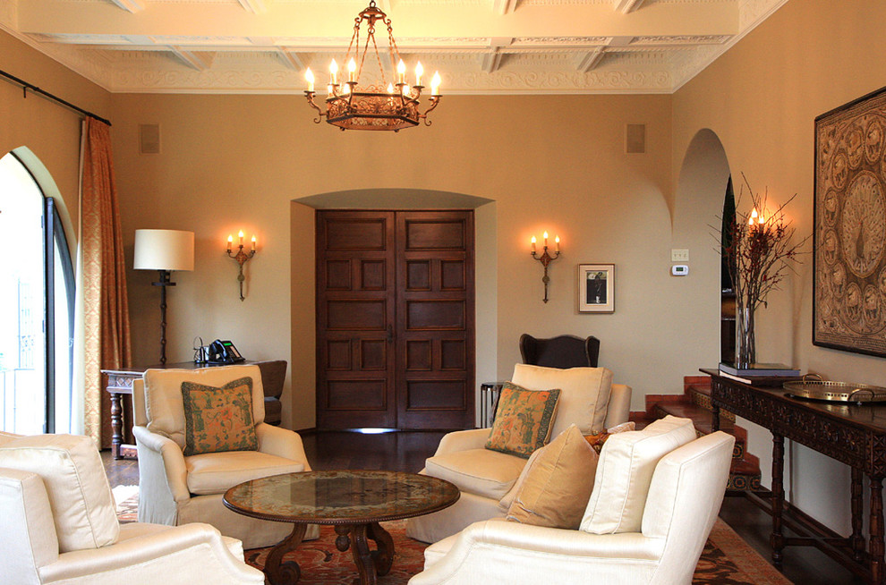 На фото: большая изолированная гостиная комната в средиземноморском стиле с бежевыми стенами, темным паркетным полом и коричневым полом