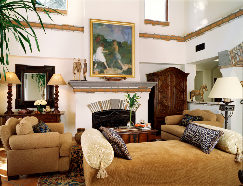 На фото: гостиная комната в средиземноморском стиле с белыми стенами и стандартным камином