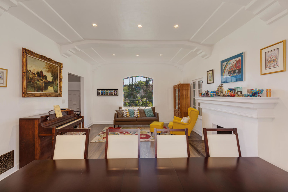 Mittelgroßes, Offenes Klassisches Wohnzimmer mit weißer Wandfarbe, dunklem Holzboden, Kamin und verputzter Kaminumrandung in Los Angeles