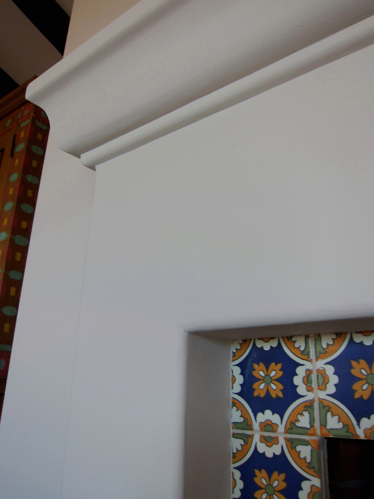 Идея дизайна: маленькая изолированная гостиная комната в средиземноморском стиле с белыми стенами, паркетным полом среднего тона, стандартным камином, скрытым телевизором, фасадом камина из плитки и коричневым полом для на участке и в саду