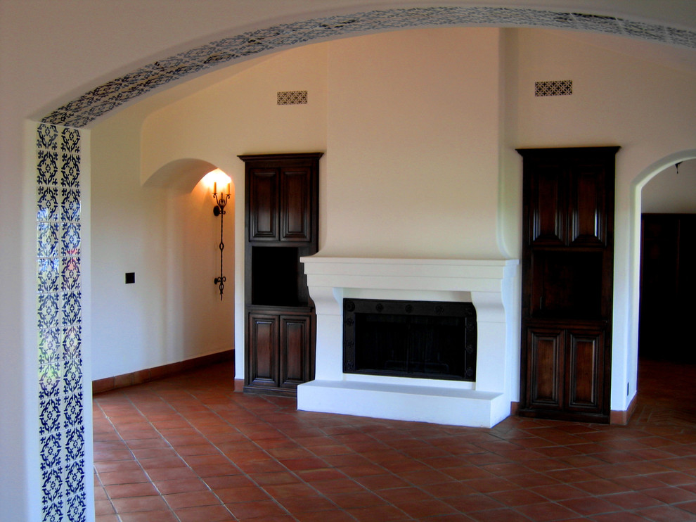 Exempel på ett mellanstort medelhavsstil separat vardagsrum, med vita väggar, en standard öppen spis, en väggmonterad TV, klinkergolv i terrakotta och rött golv