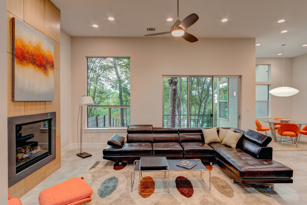 Modern open plan living room in Austin with beige walls, a standard fireplace and a metal fireplace surround.