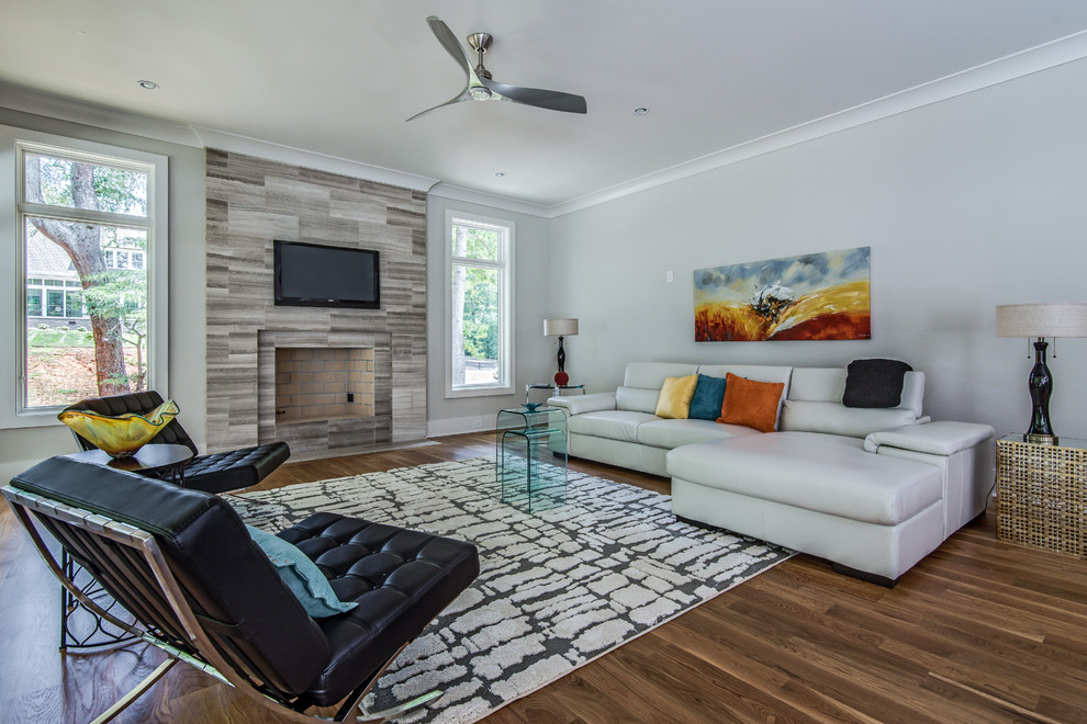 Idee per un soggiorno classico con pareti blu, camino classico, TV a parete e pavimento in legno massello medio