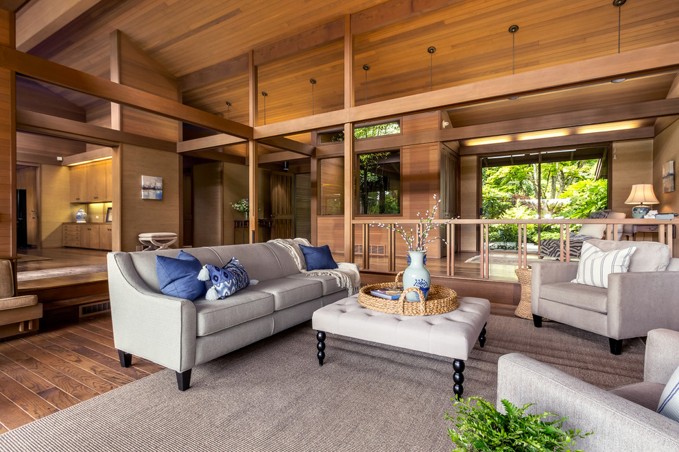 Photo of an expansive contemporary open plan living room in Seattle with a home bar, brown walls, medium hardwood flooring, a standard fireplace, a stone fireplace surround and brown floors.