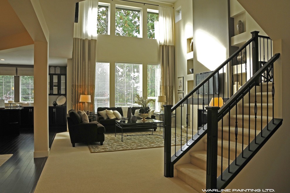 Photo of an open plan living room in Vancouver with beige walls, carpet, a standard fireplace and a wall mounted tv.