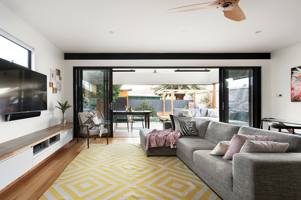 Immagine di un soggiorno contemporaneo di medie dimensioni con parquet chiaro, parete attrezzata e pavimento marrone