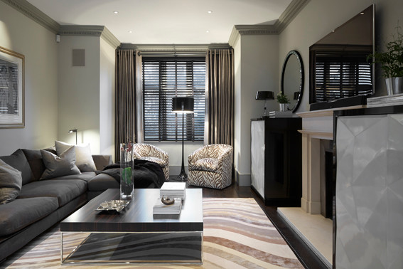 Mittelgroßes, Offenes Modernes Wohnzimmer mit grüner Wandfarbe, Teppichboden, Kamin, Kaminumrandung aus Stein und freistehendem TV in London