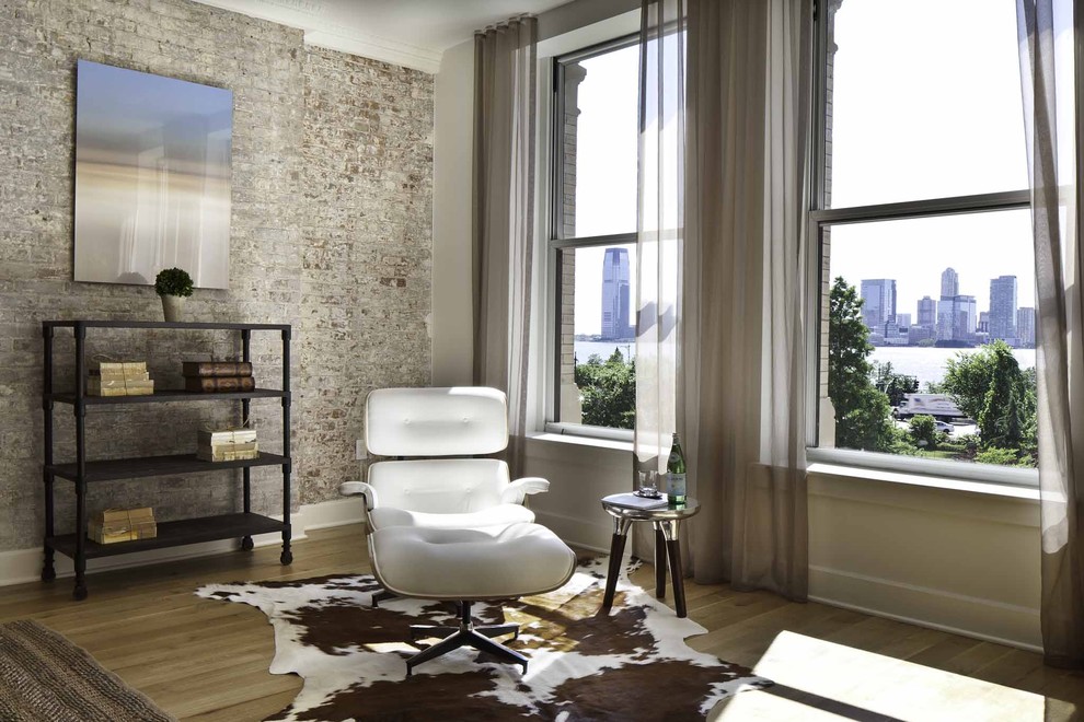 This is an example of a large urban mezzanine living room in New York with white walls and light hardwood flooring.
