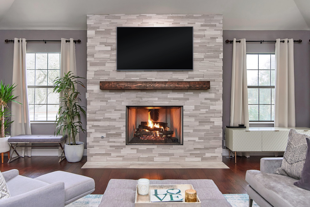 Exempel på ett modernt vardagsrum, med grå väggar, mörkt trägolv, en standard öppen spis, en spiselkrans i trä, en väggmonterad TV och brunt golv