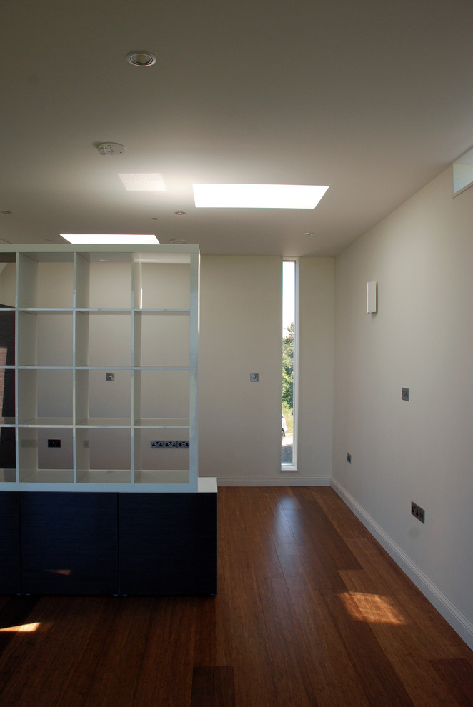 Imagen de salón abierto contemporáneo de tamaño medio con paredes blancas y suelo de madera en tonos medios
